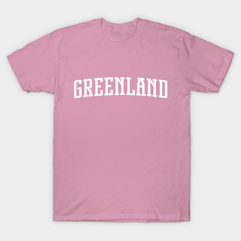 May include: A pink t-shirt with the word "GREENLAND" printed in white on the front.