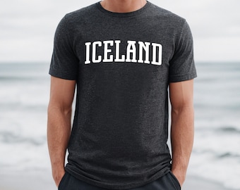 Puede incluir: Una camiseta gris oscuro jaspeada con la palabra "ICELAND" impresa en blanco en la parte delantera.
