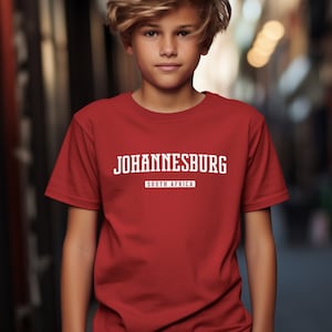 May include: A red t-shirt with white text that reads "JOHANNESBURG" and "SOUTH AFRICA".