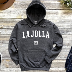 May include: A dark gray hooded sweatshirt with the text "LA JOLLA CA" printed in white on the front.