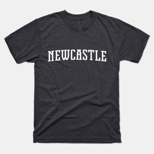 K&ouml;nnte beinhalten: Ein dunkelgraues T-Shirt mit dem Wort "NEWCASTLE" in Wei&szlig; auf der Vorderseite.