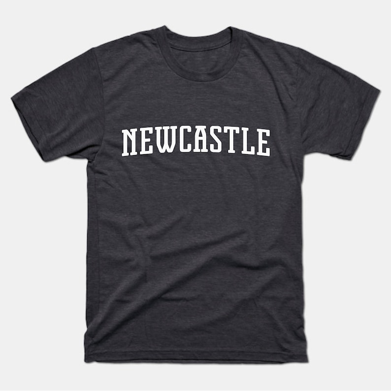 K&ouml;nnte beinhalten: Ein dunkelgraues T-Shirt mit dem Wort "NEWCASTLE" in Wei&szlig; auf der Vorderseite.