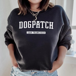 May include: Black sweatshirt with white text that reads "DOGPATCH SAN FRANCISCO".