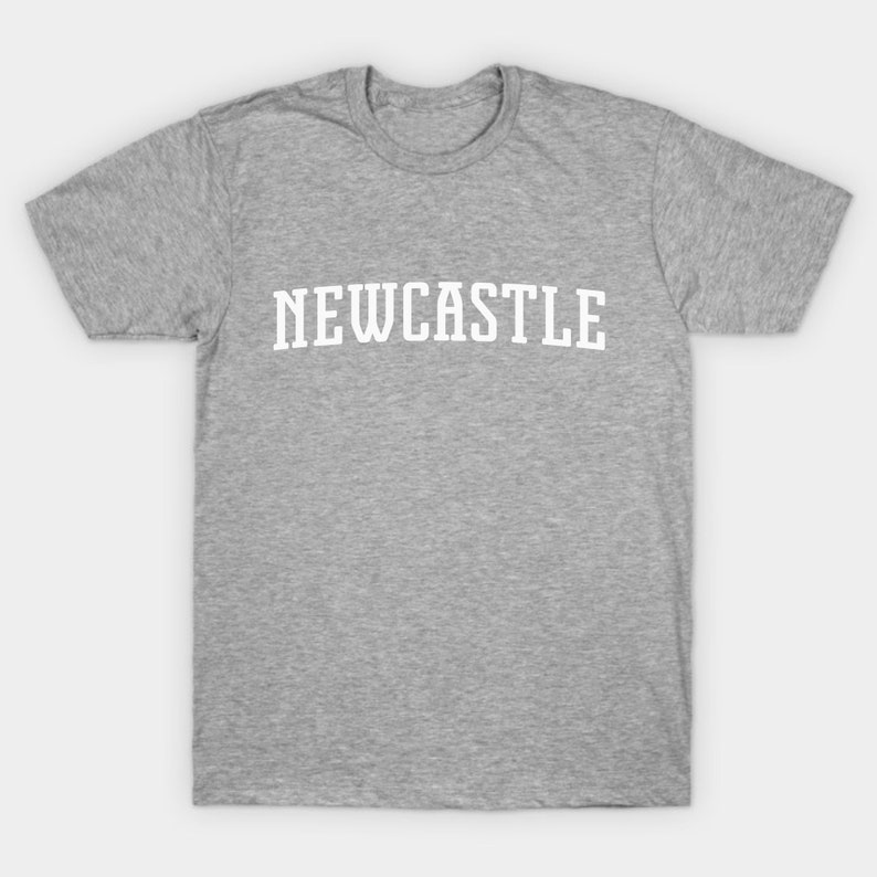 K&ouml;nnte beinhalten: Ein hellgraues T-Shirt mit dem Wort "NEWCASTLE" in wei&szlig; auf der Vorderseite.