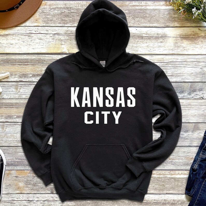 May include: Black hooded sweatshirt with white text that reads "KANSAS CITY".