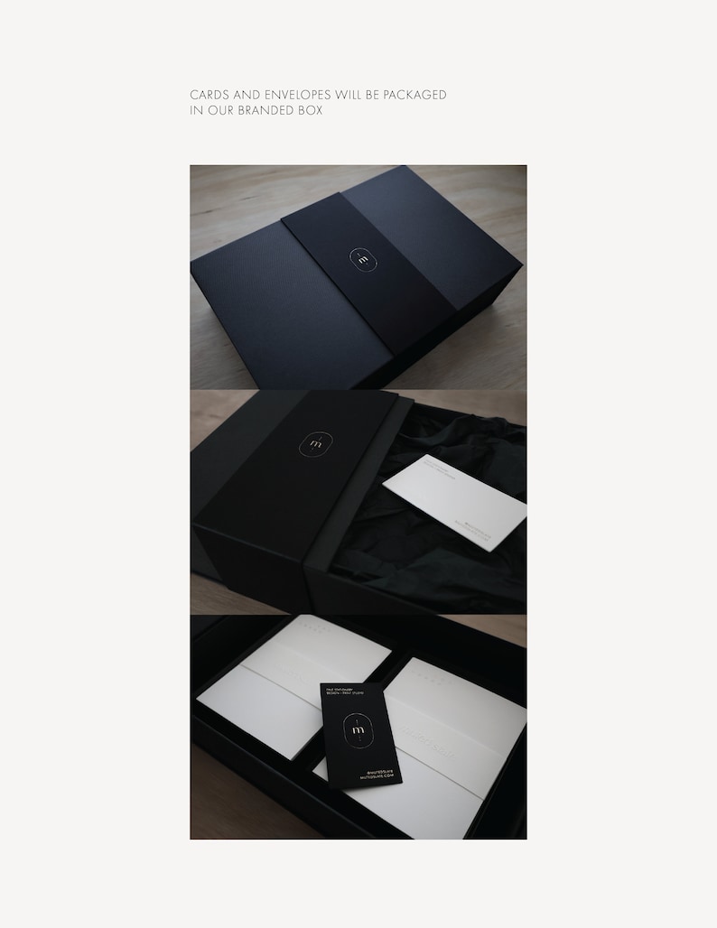 May include: A black rectangular box with a branded sleeve featuring a white letter m logo. The box contains white envelopes and cards wrapped in black tissue paper, with a small black card displaying the same white letter m logo on top.
