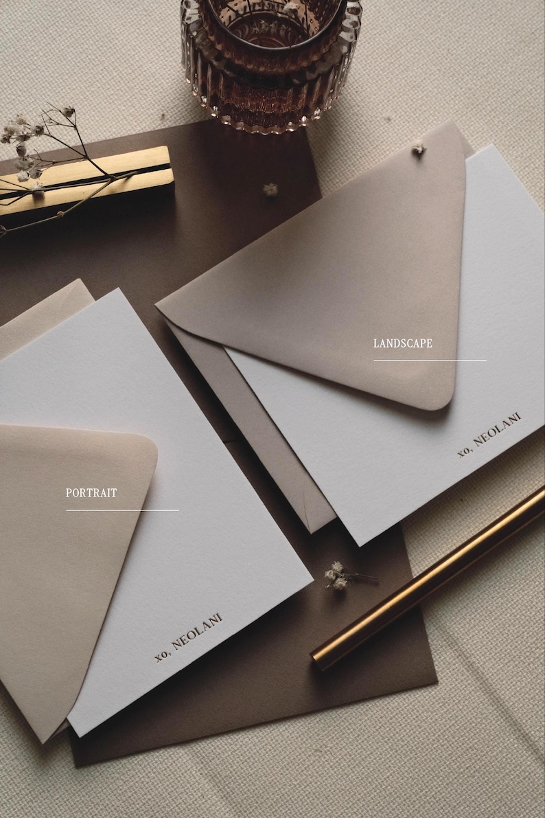 May include: Two white stationery cards with matching beige envelopes, one in portrait and one in landscape orientation. Each card features the black printed text 'xo, NEOLANI' in the bottom corner. The set includes a gold pen and a glass holder.