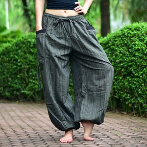 May include: Gray striped pants with a drawstring waist and side pockets. The pants are loose fitting and have a wide leg.