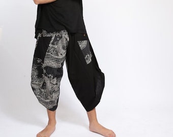 May include: A man wearing a black short-sleeved shirt with a v-neck and black pants with a white and gray patterned design.