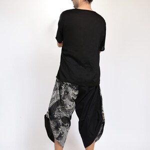 May include: A black short-sleeved shirt with a black and white patterned pair of pants. The pants have a loose fit and a wide leg.