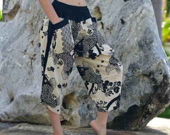 May include: Cropped, loose-fitting pants with a black and cream fish pattern. The pants have a black waistband and pockets. The fabric is lightweight, and the pants are knee-length.
