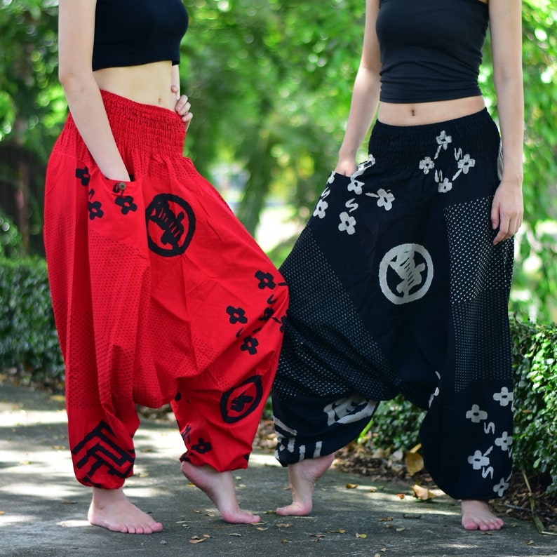 Puede incluir: Dos pares de pantalones holgados de pierna ancha con un dise&ntilde;o estampado colorido. Un par es rojo con detalles negros y el otro es negro con detalles blancos. Ambos pares tienen una cintura con cord&oacute;n y bolsillos.