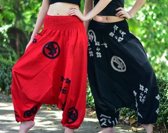 May include: Two pairs of loose-fitting, printed trousers with an elastic waistband. One pair is red with black designs and the other is black with white designs.