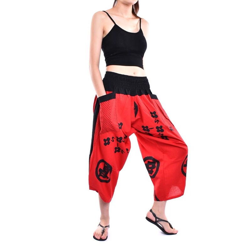 May include: Red and black printed pants with a wide leg and elastic waistband. The pants have a black side panel and a black and white pattern.