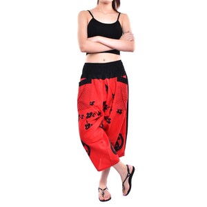 May include: Red and black printed pants with a wide leg and elastic waistband. The pants have a floral design and a black circle pattern.