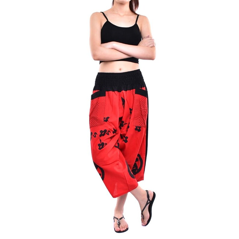 May include: Red and black printed pants with a wide leg and elastic waistband. The pants have a floral design and a black circle pattern.