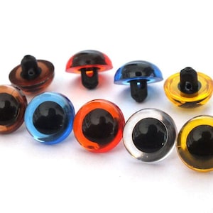May include: A collection of colorful plastic craft eyes in various colors, including brown, blue, orange, clear, and yellow. Each eye has a black pupil and a post for attachment. Ideal for crafting and toy making.