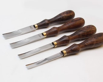 May include: Four wood carving gouges with dark brown wooden handles and silver blades. The blades are curved and have brass ferrules. The gouges are labeled with their sizes: 12mm, 10mm, 8mm, and 6mm.