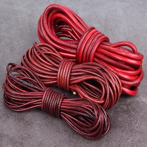 Puede incluir: Tres madejas de cordón de cuero rojo, enrolladas y atadas. Los cordones varían en tamaño y tono, desde un borgoña profundo hasta un rojo vibrante. El cuero parece liso y duradero, adecuado para manualidades o joyería.