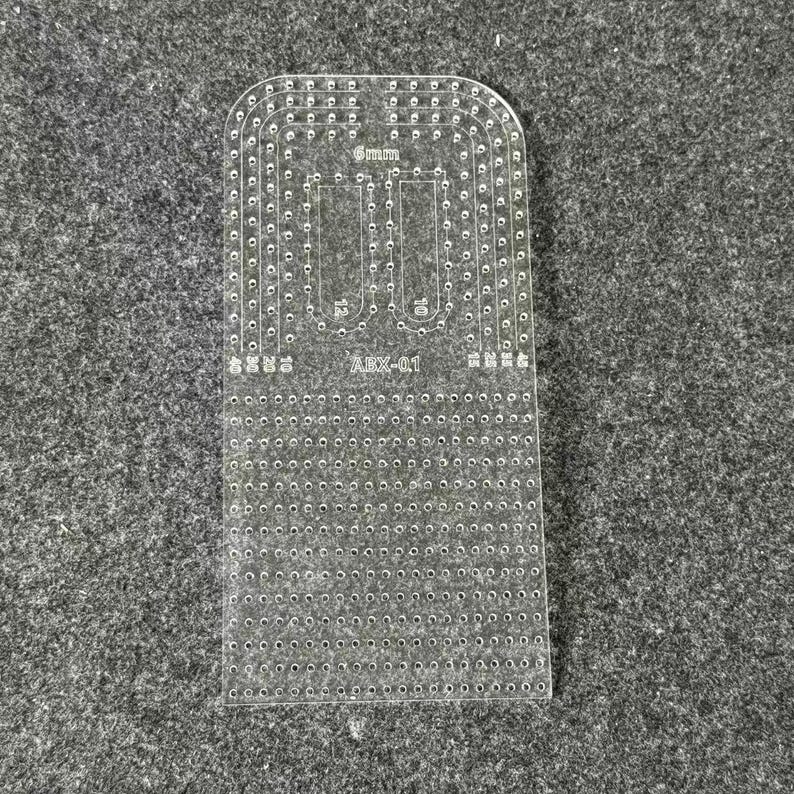 Peut inclure: Un gabarit en acrylique transparent pour le travail du cuir, dot&eacute; d'un bord sup&eacute;rieur arrondi, de nombreux trous de couture pr&eacute;-perc&eacute;s et de marquages grav&eacute;s incluant 6mm, 10, 12 et le code mod&egrave;le ABX-01 pour un alignement pr&eacute;cis.