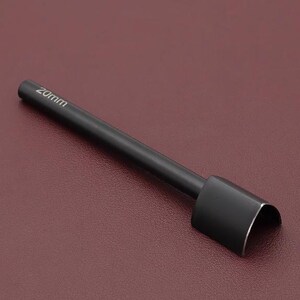 May include: A black leathercraft tool with a curved cutting edge. The tool has a cylindrical handle and a blade that is 20mm wide. The tool is designed for cutting leather and other materials.