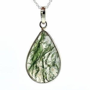 May include: A silver pendant necklace featuring a teardrop-shaped green moss agate stone.