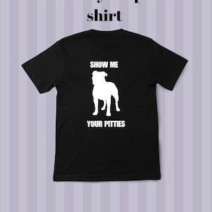 Pode incluir: Camiseta preta com texto branco e silhueta branca de um cão. A camiseta tem a frase "show me your pitties" no topo e as palavras "SHOW ME" e "YOUR PITTIES" nas costas.