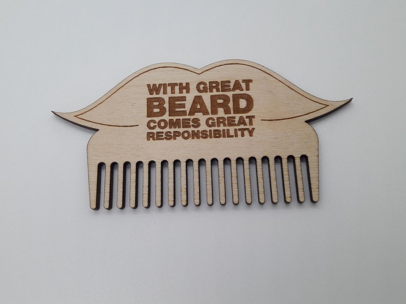 Op de afbeelding: Houten baardkam in de vorm van een snor met de tekst "With great beard comes great responsibility".