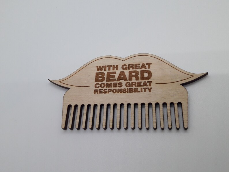 Op de afbeelding: Houten baardkam in de vorm van een snor met de tekst "With great beard comes great responsibility".