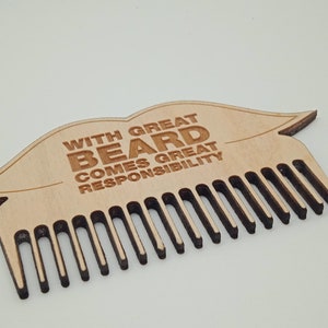 Op de afbeelding: Houten baardkam met een lipvormig ontwerp en de tekst "With great beard comes great responsibility".