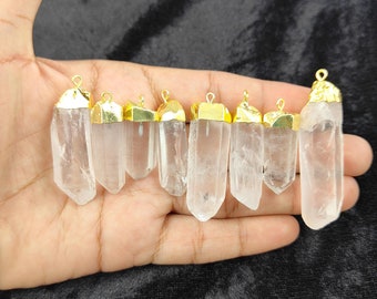 May include: Eight clear quartz crystal pendants with gold-plated tops. The pendants are all different sizes and shapes, but they are all clear and have a smooth, polished finish.