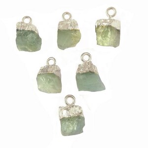 May include: Six silver and green gemstone pendants. Each pendant features a raw, irregular shaped green gemstone with a silver bail.