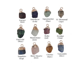 May include: Twelve gemstone charms, each representing a different month of the year. The charms are made of gold-plated metal and feature a variety of colors, including red, blue, green, purple, and pink.