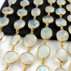 Peut inclure: Un brin de perles de pierre de lune blanche avec des accents dor&eacute;s. Les perles sont de forme ovale et ont une finition lisse et polie. Les accents dor&eacute;s sont petits et d&eacute;licats.