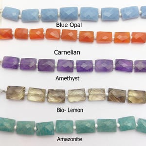 Puede incluir: Primer plano de cinco hilos de cuentas de piedras preciosas. Los hilos incluyen ópalo azul, cornalina, amatista, bio-limón y amazonita. Cada hilo presenta cuentas rectangulares facetadas ensartadas con pequeñas cuentas blancas. Las etiquetas de texto identifican cada piedra preciosa.