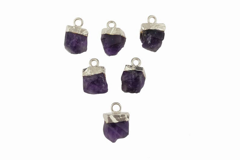 May include: Six purple amethyst crystal charms with silver accents. Each charm has a loop for attaching to jewelry.