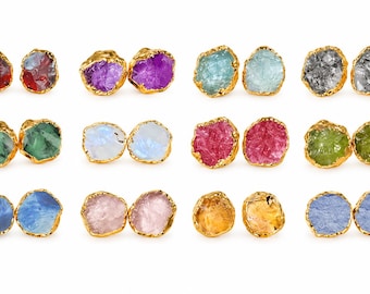 Puede incluir: Doce pares de pendientes de botón con piedras preciosas en bruto y sin tallar en varios colores, incluyendo rojo, morado, azul claro, gris, verde, blanco, rosa, amarillo y naranja, engastados en metal de tono dorado.