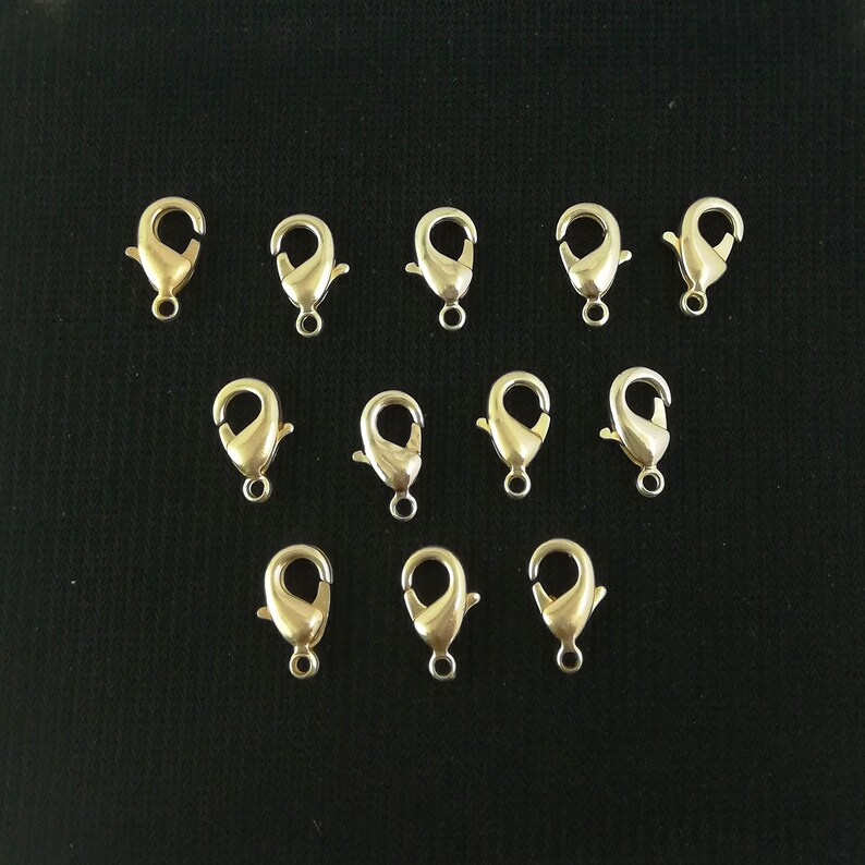 Puede incluir: Doce cierres de langosta de metal dorado, com&uacute;nmente utilizados para la fabricaci&oacute;n de joyas.