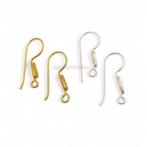 May include: Four earring hooks, two gold-toned and two silver-toned, are displayed against a white background. The hooks have a curved design with a small loop at the bottom for attaching earrings. The gold hooks have a textured detail.