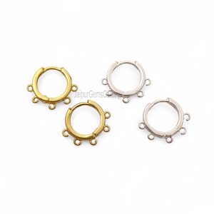 Könnte beinhalten: Vier Creolen-Ohrringe, zwei goldfarbene und zwei silberfarbene, jeweils mit mehreren kleinen Schlaufen zum Anbringen von Anhängern oder anderen dekorativen Elementen. Die Ohrringe werden vor weißem Hintergrund präsentiert.