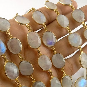 Peut inclure: Un collier de perles de pierre de lune blanche avec des accents dor&eacute;s. Les perles sont de forme ovale et ont une finition lisse et polie. Les accents dor&eacute;s sont petits et d&eacute;licats.
