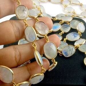 Peut inclure: Un collier en cha&icirc;ne dor&eacute;e avec des perles de pierre de lune de forme ovale. Les perles sont de couleur blanc laiteux avec un l&eacute;ger reflet iridescent.