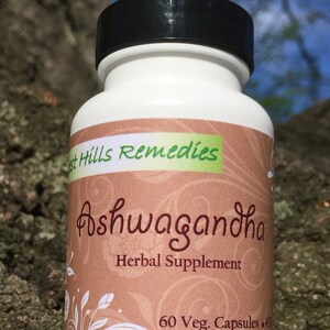 May include: A brown bottle with a white label that says "West Hills Remedies Ashwagandha Herbal Supplement 60 Veg. Capsules"