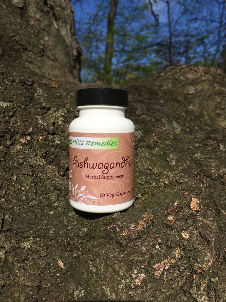 May include: A white bottle with a black lid and a brown label that says "Forest Hills Remedies Ashwagandha Herbal Supplement 60 Veg. Capsules"