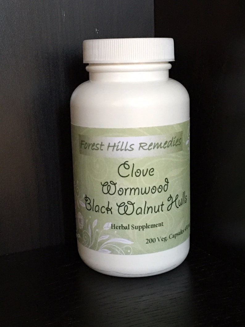 May include: White plastic bottle with a green label that reads "Forest Hills Remedies Clove Wormwood Black Walnut Hulls Herbal Supplement 200 Veg Capsules"