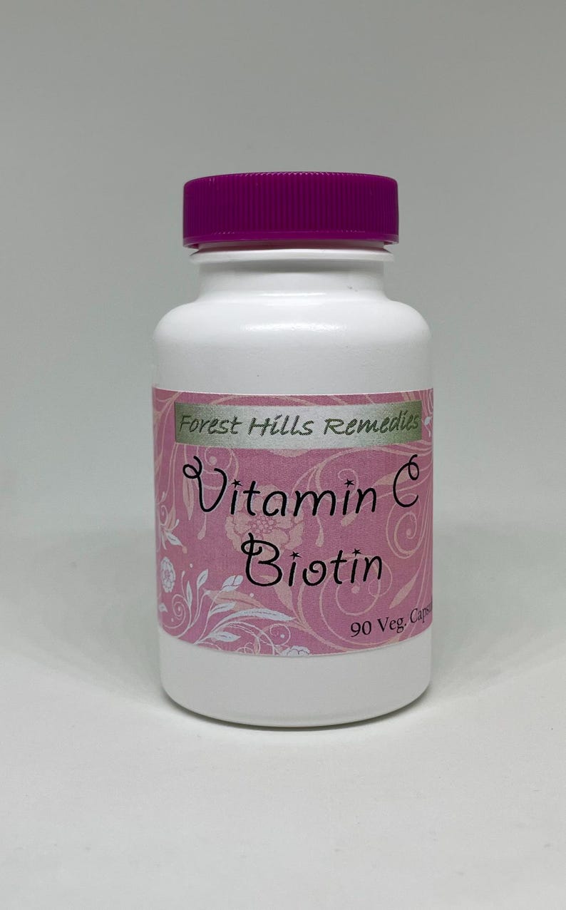 May include: A white supplement bottle with a purple cap. The label reads "Vitamin C Biotin" and "Forest Hills Remedies". The bottle contains 90 vegetarian capsules.