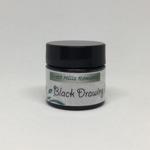 May include: A small black jar with a white label that reads "Forest Hills Remedies Black Drawing Salve".