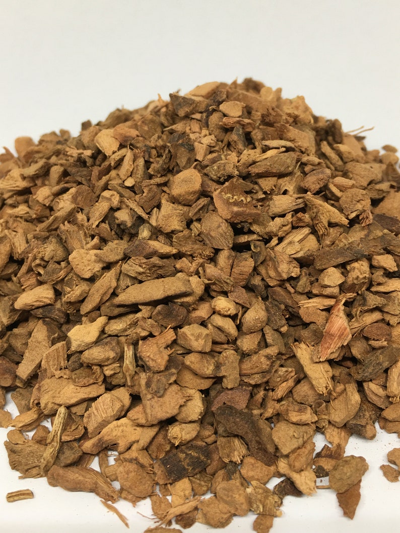 May include: A close-up of a pile of dried, brown, and slightly reddish-brown bark chips. The chips are irregularly shaped and range in size from small to medium.