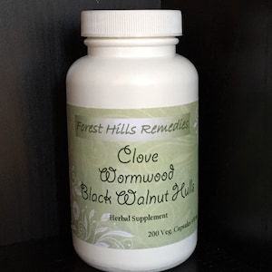 May include: White plastic bottle with a green label that reads "Forest Hills Remedies Clove Wormwood Black Walnut Hulls Herbal Supplement 200 Veg. Capsules 500 mg"