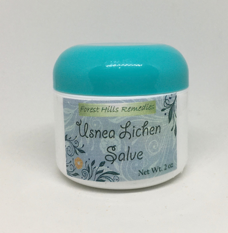 May include: A white jar with a teal lid, labelled "Forest Hills Remedies Usnea Lichen Salve" with a floral design and "Net Wt. 2 oz".